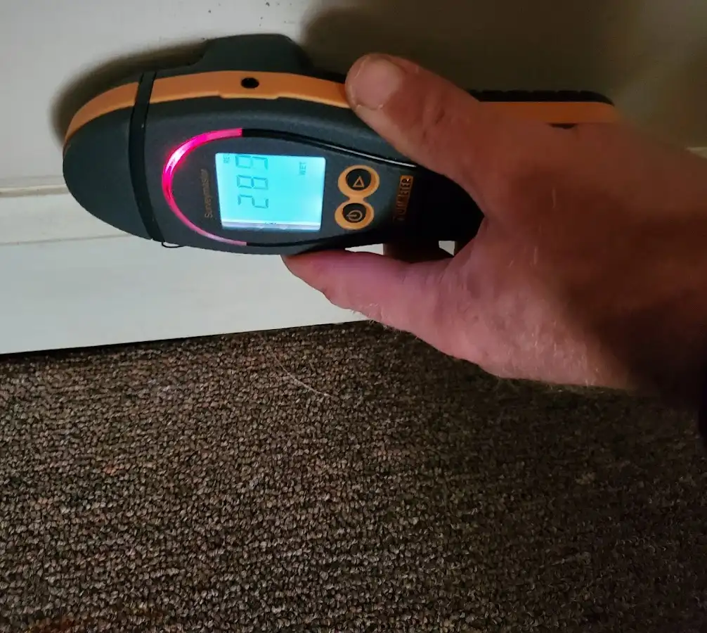 Moisture detection at baseboard during Storm Damage Restoration in Clay